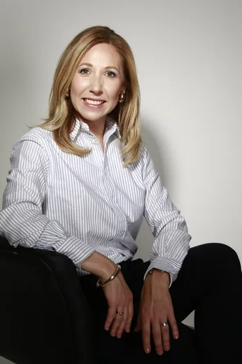 Laure Genin, Docteur en Pharmacie et directrice marketing senior, assise dans un fauteuil, portrait en noir et blanc.